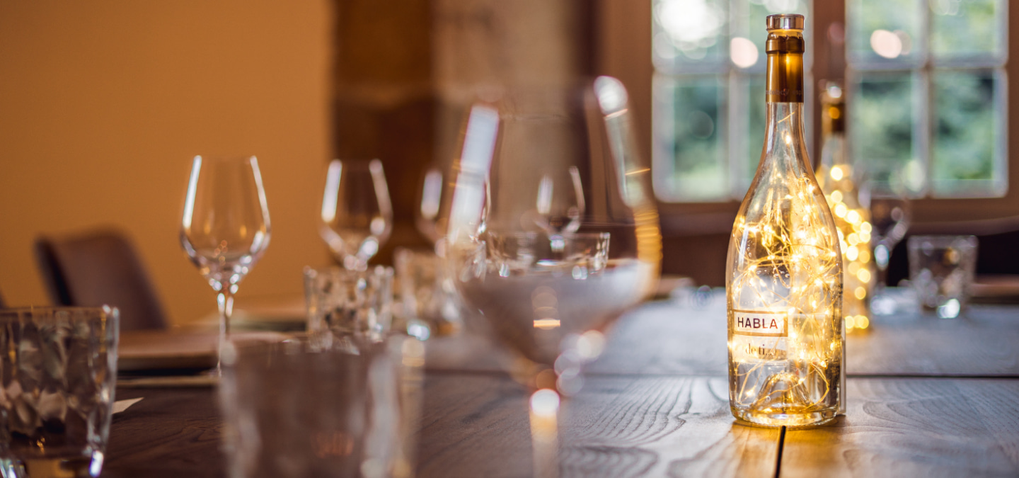 Glasses, tumblers and bottles of alcoholic beverages on a dining table