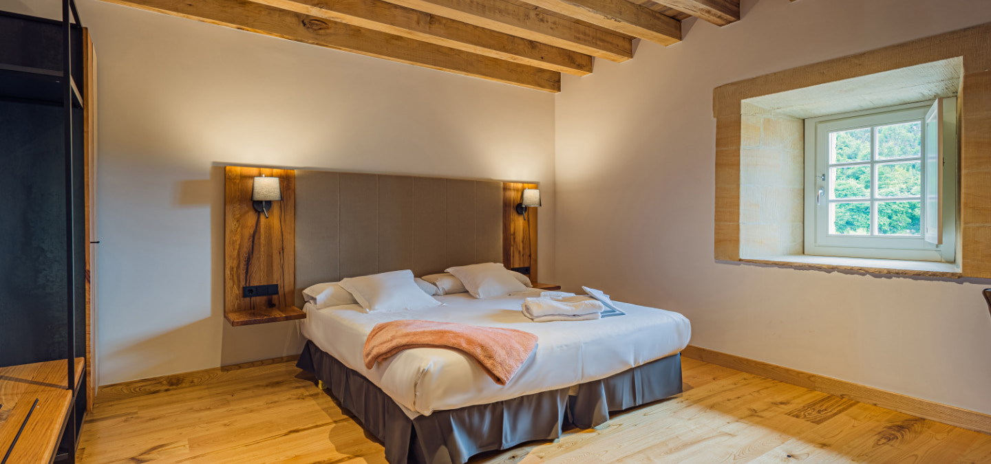 Bed in one of the double rooms of the Hotel Palacio de los Acevedo in Cantabria